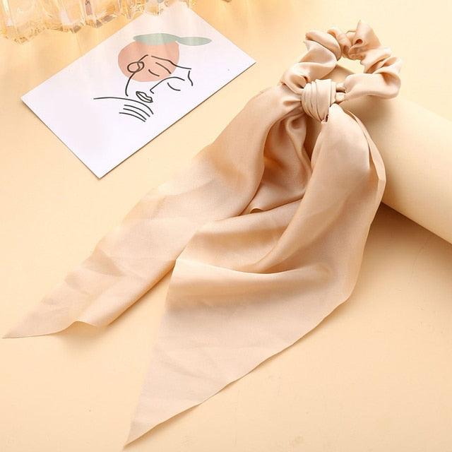 Beige silk scarf with a bow on a beige background