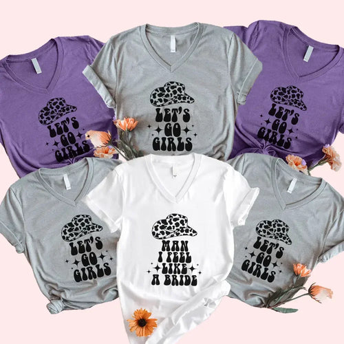 Collection of t-shirts with 'Let's Go Girls' and 'Man I Feel Like a Bride' text on a pink background.