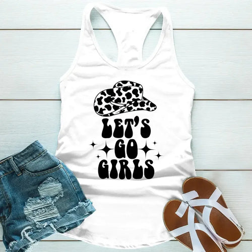 White tank top with 'Let's Go Girls' text and leopard print cap, paired with denim shorts and sandals on a light wooden surface.