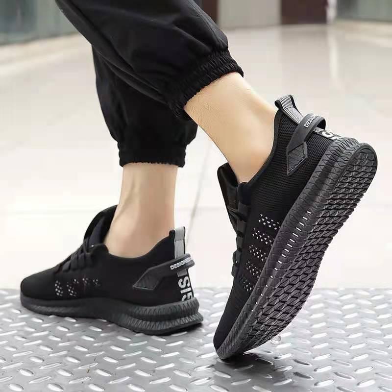 Black athletic shoes worn by a person on a metallic floor