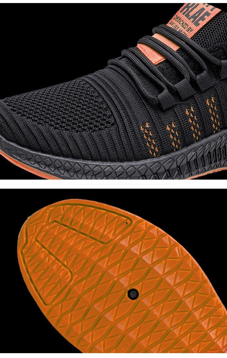 Black athletic shoe with orange accents and sole detail