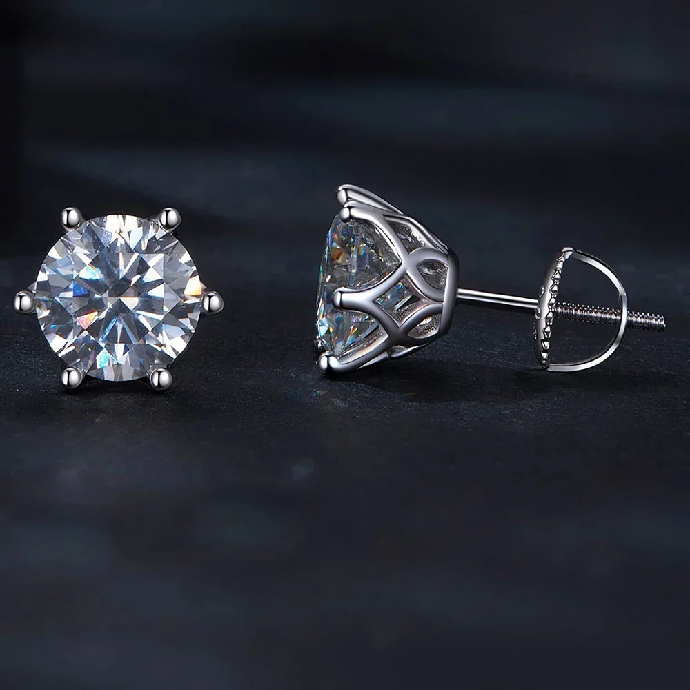 Two silver stud earrings with clear gemstones on a dark background