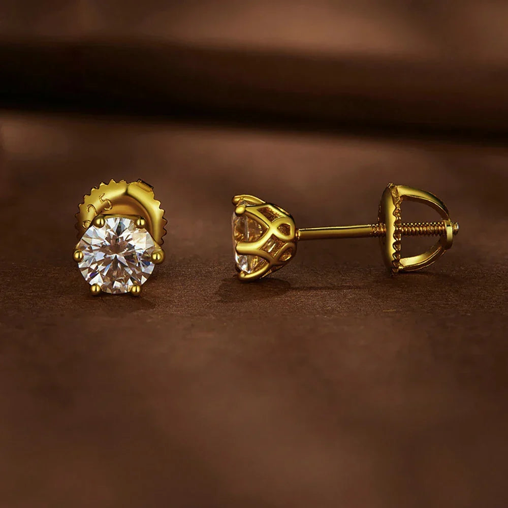 Gold earrings with clear gemstones on a brown background