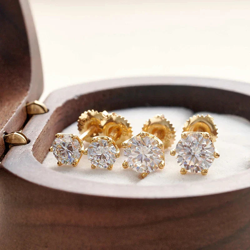 Gold and diamond stud earrings in an open jewelry box.