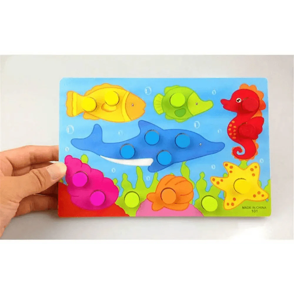Colorful puzzle with sea-themed figures held by a hand on a light gray background