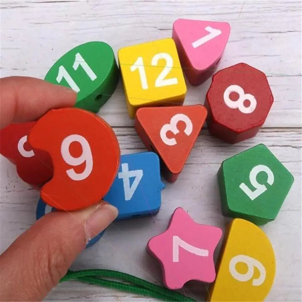 Colorful number blocks on a white wooden surface with a hand holding one of them.