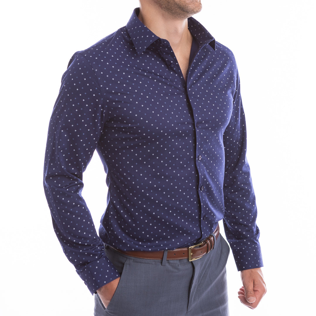 Man wearing a navy blue shirt with white polka dots on a white background