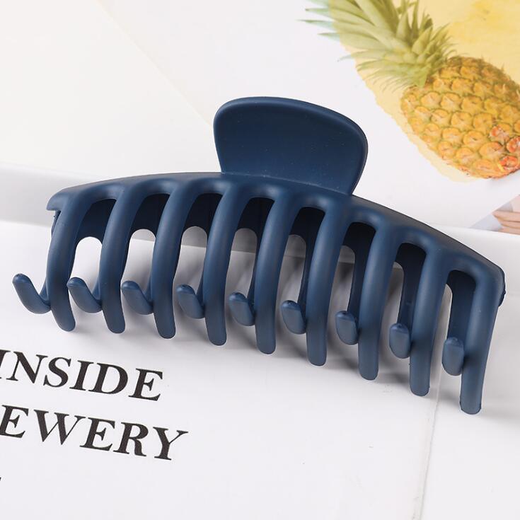 Navy blue hair clip on a magazine with a pineapple in the background