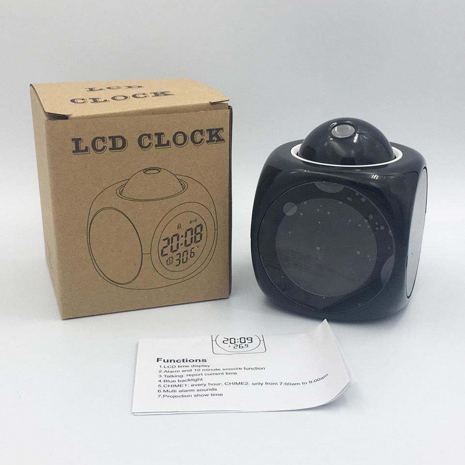 Black LCD clock with packaging and user manual on a white background