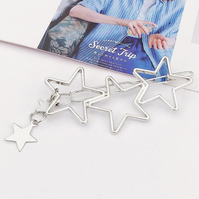 Star-shaped clips on a white surface with a magazine in the background