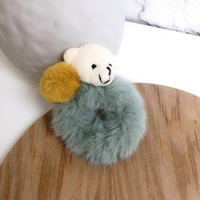 Fluffy keychain with a teddy bear design on a wooden surface