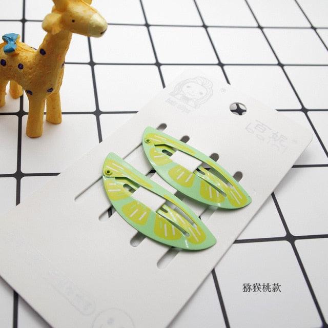 Green hair clips on a white card with a grid background