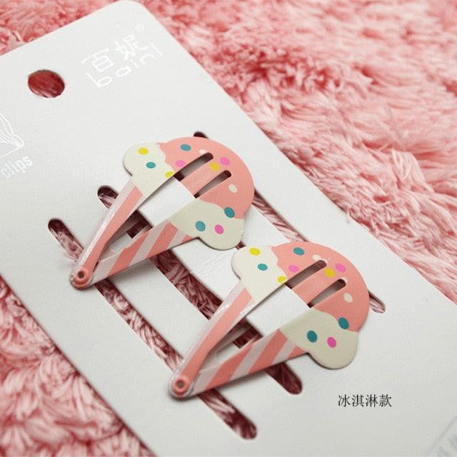 Two pink ice cream-themed hair clips on a white card with a pink fluffy background.
