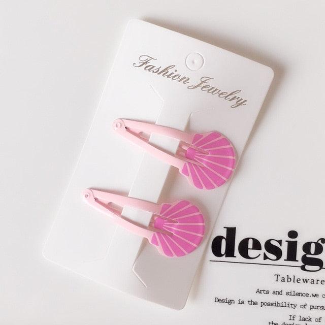 Pink shell-shaped hair clips on a 'Fashion Jewelry' card with a white background.