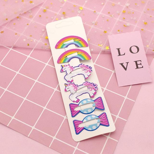 Set of colorful hair clips on a pink grid background with 'LOVE' card.