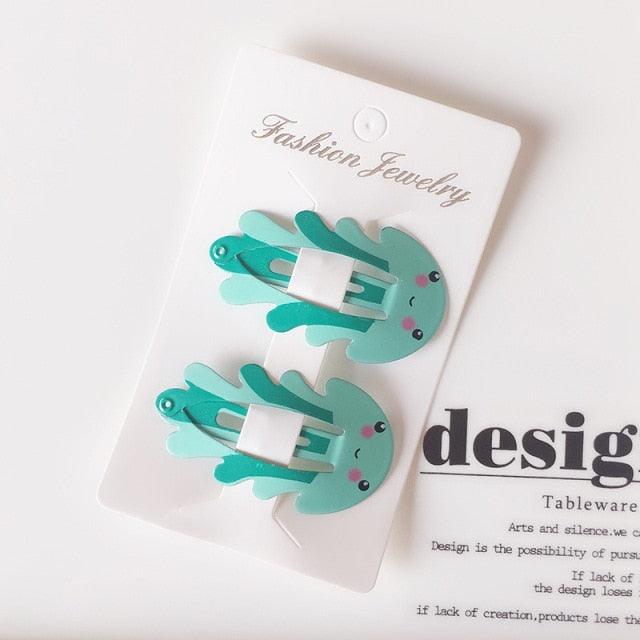 Pair of teal hair clips on a white card with 'Fashion Jewelry' text.