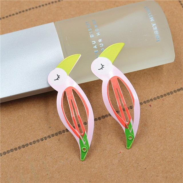 Pair of bunny-shaped hair clips on a brown surface with a blurred product packaging in the background.