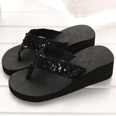 Black sandals with sequin details on a white background