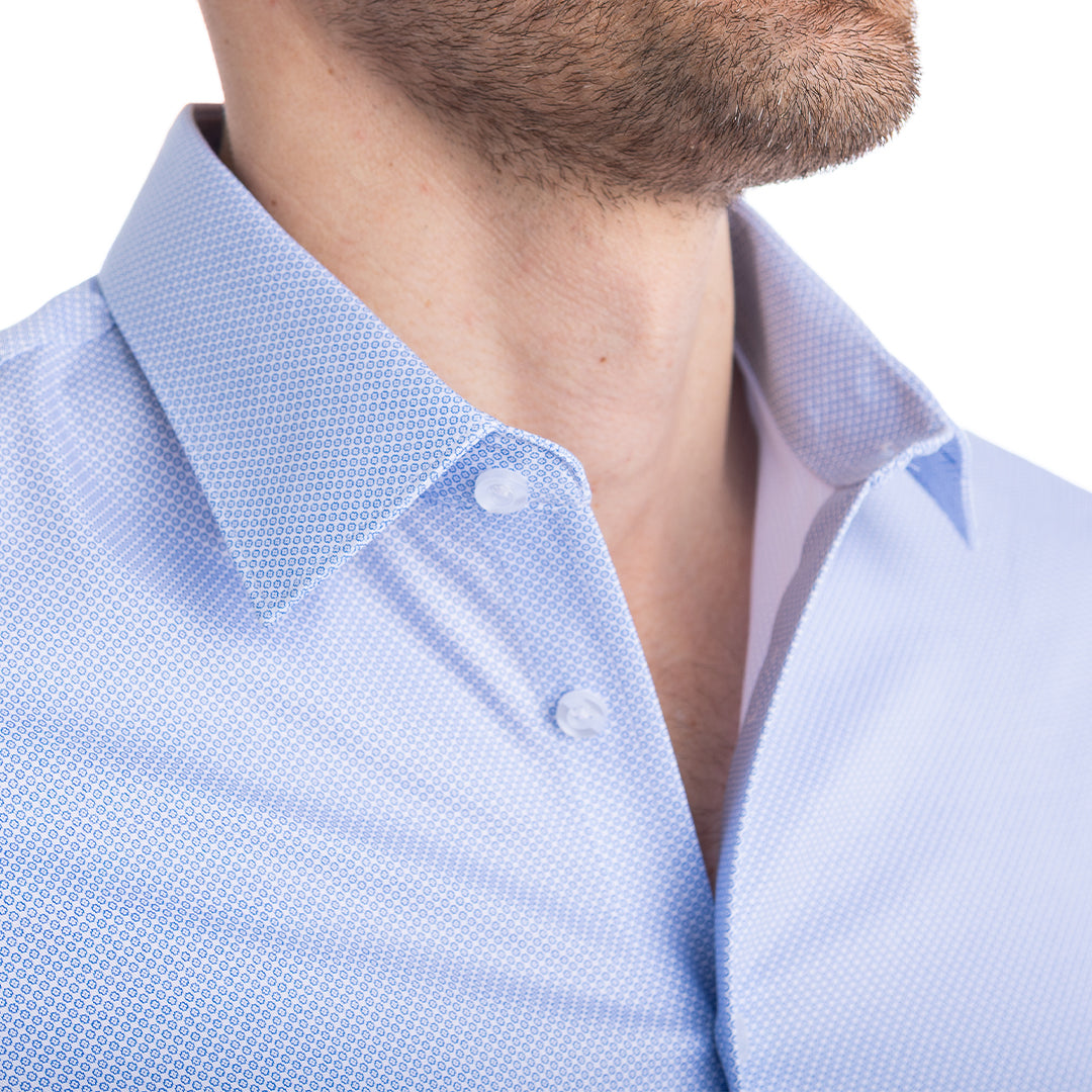 Close-up of a light blue textured shirt with white buttons on a blurred background