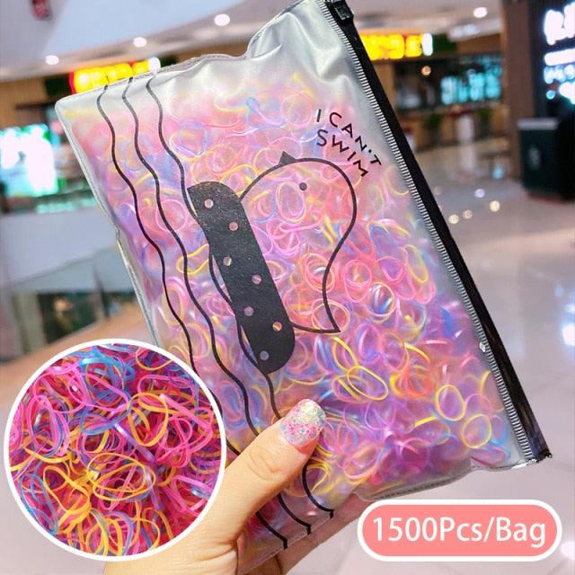 Package of colorful hair ties with a hand holding it, set against an indoor background.