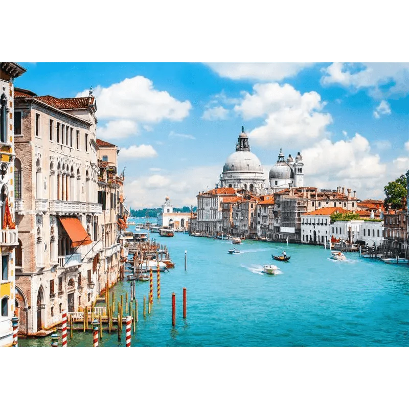 Venice cityscape with Grand Canal and historic buildings under a blue sky.
