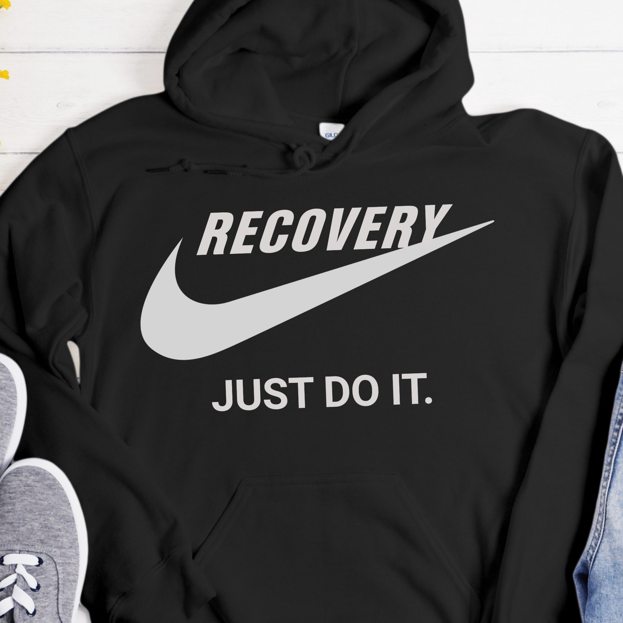 Black hoodie with 'Recovery Just Do It' text and Nike logo on a white background
