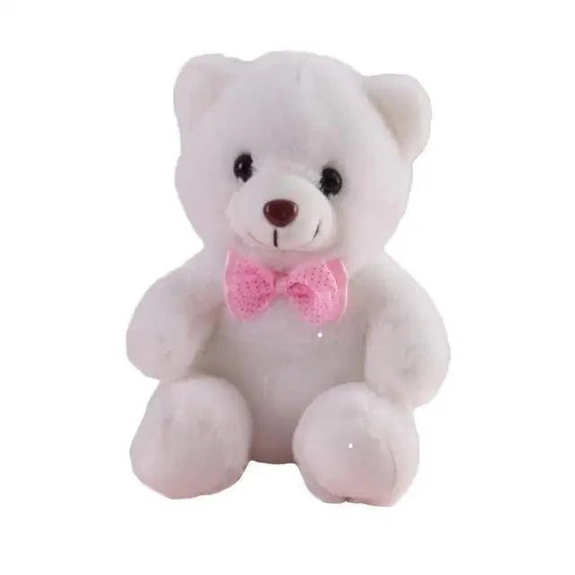 White teddy bear with a pink bow tie on a white background