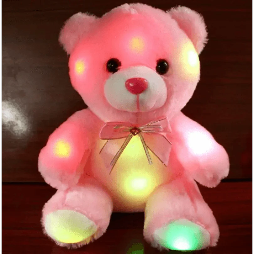 Pink teddy bear with LED lights on a dark background