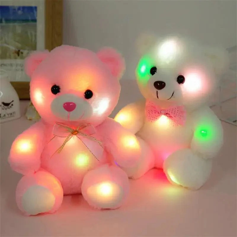 Two LED teddy bears, one pink and one white with a bow, on a light background.