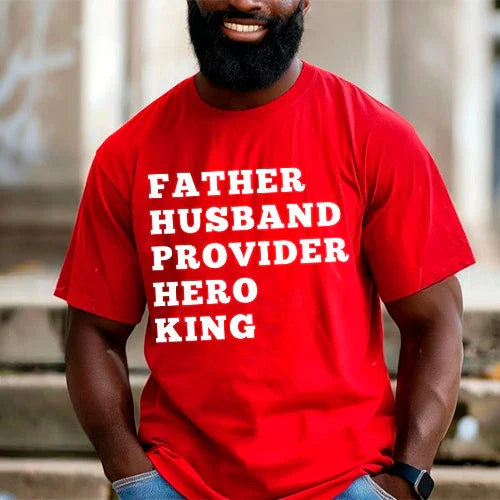 Man wearing a red t-shirt with text 'FATHER HUSBAND PROVIDER HERO KING' in an urban setting.