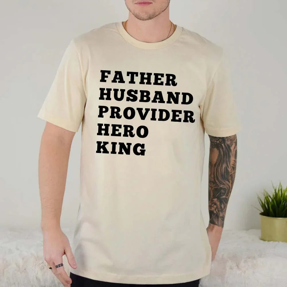 Man wearing a beige t-shirt with text 'FATHER HUSBAND PROVIDER HERO KING' on a light background.