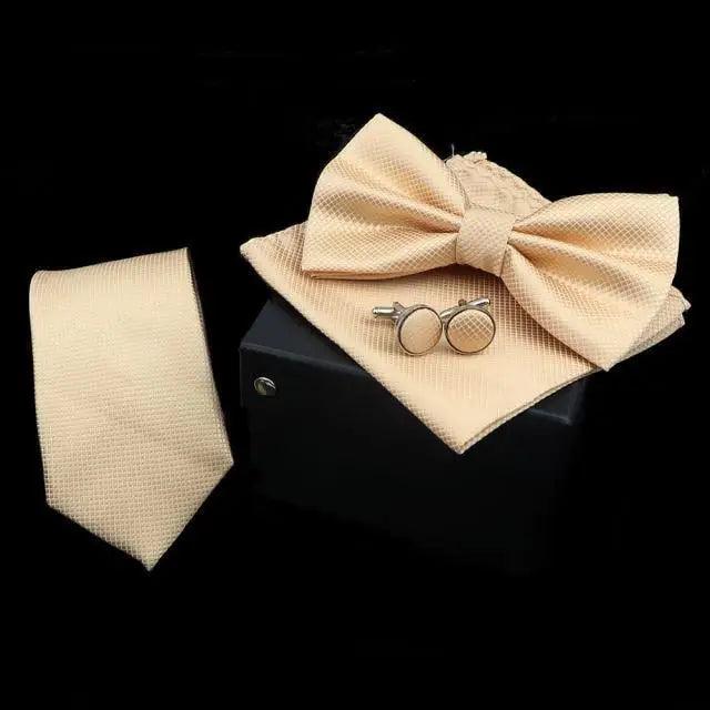 Beige bow tie, pocket square, and cufflinks on a black background