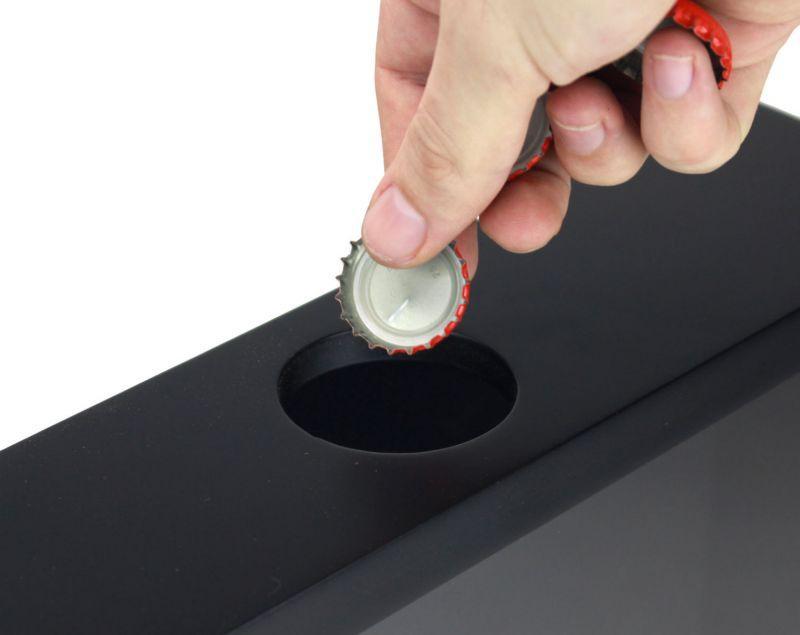 Person using a bottle opener on a black surface with a white background