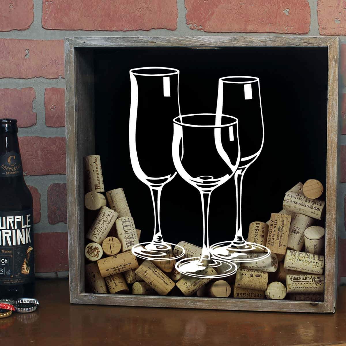 Decorative wall art with wine glasses and corks against a brick wall.