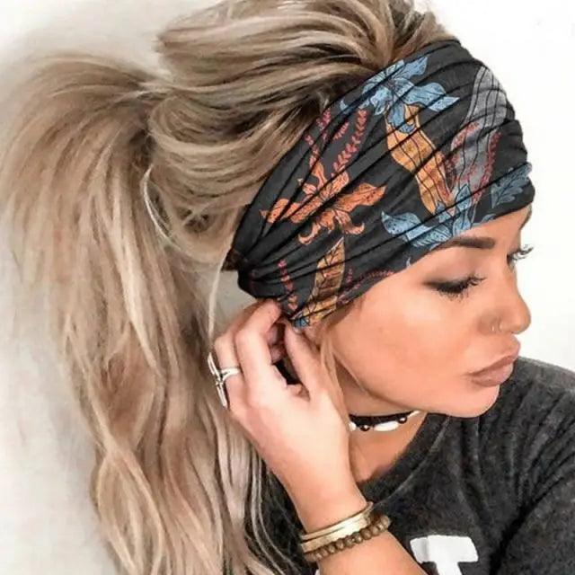 Woman wearing a patterned headband with her hair in a ponytail against a white background