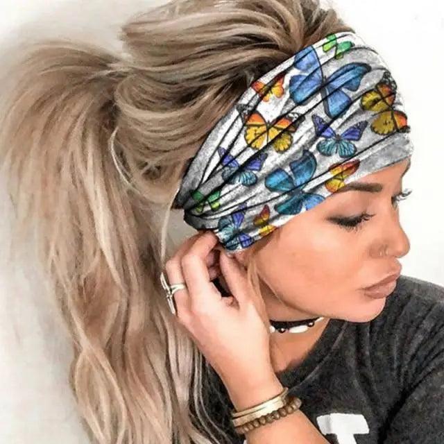 Woman wearing a colorful butterfly-patterned headband with a plain background