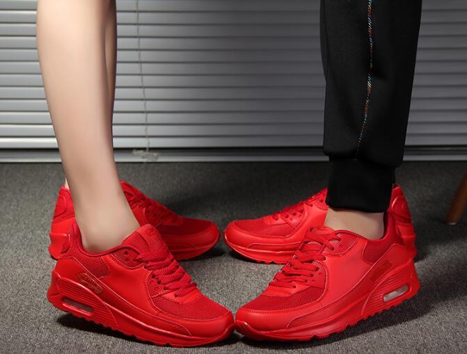Red sneakers worn by a person on a neutral background